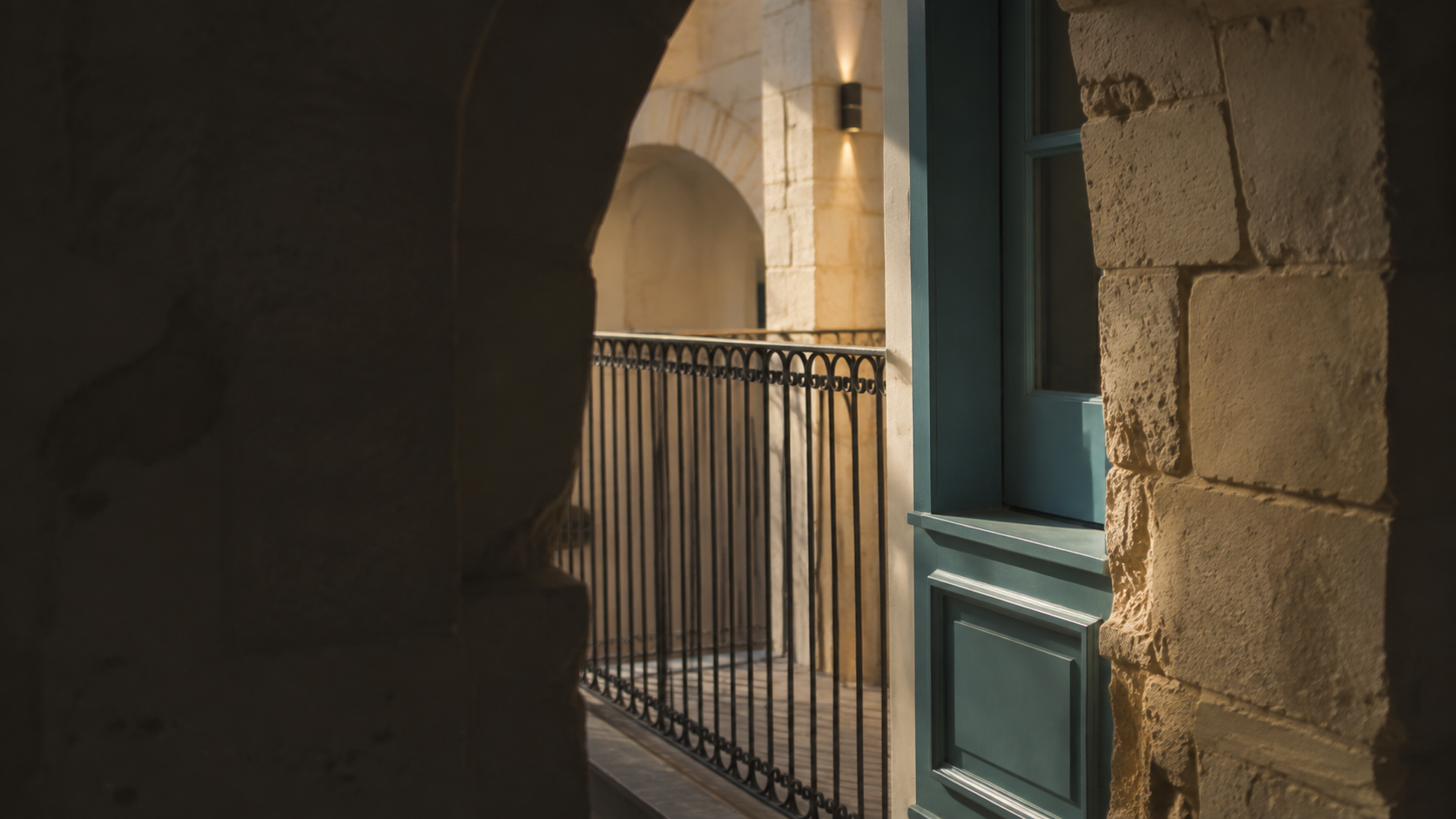 Limestone archway and wrought iron in warm light